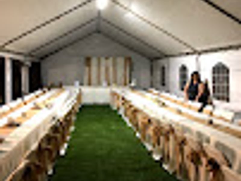 Outdoor wedding tent setup with white draping